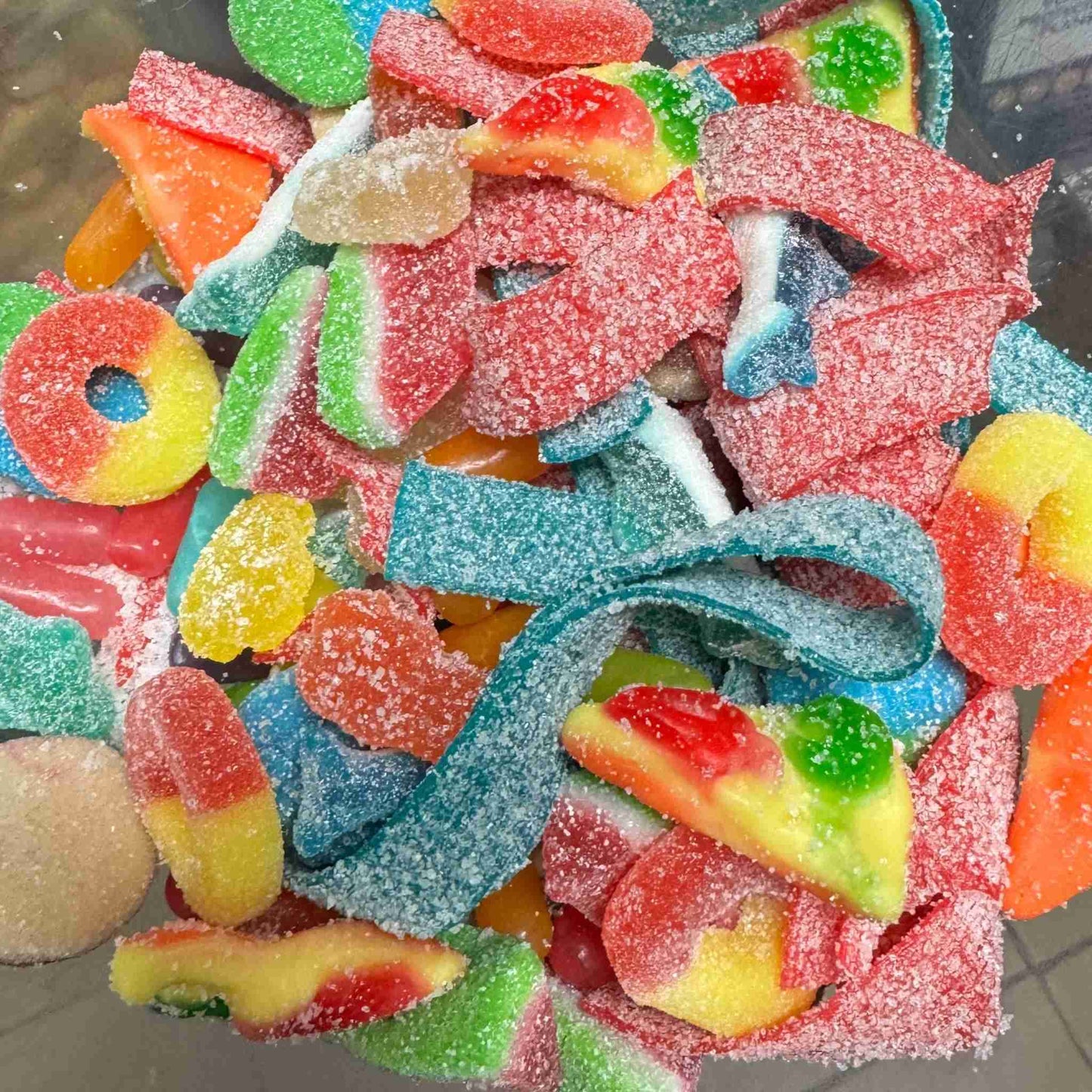 Close-up of sour gummy mix with belts, worms, rings, and other sweet and sour gummies