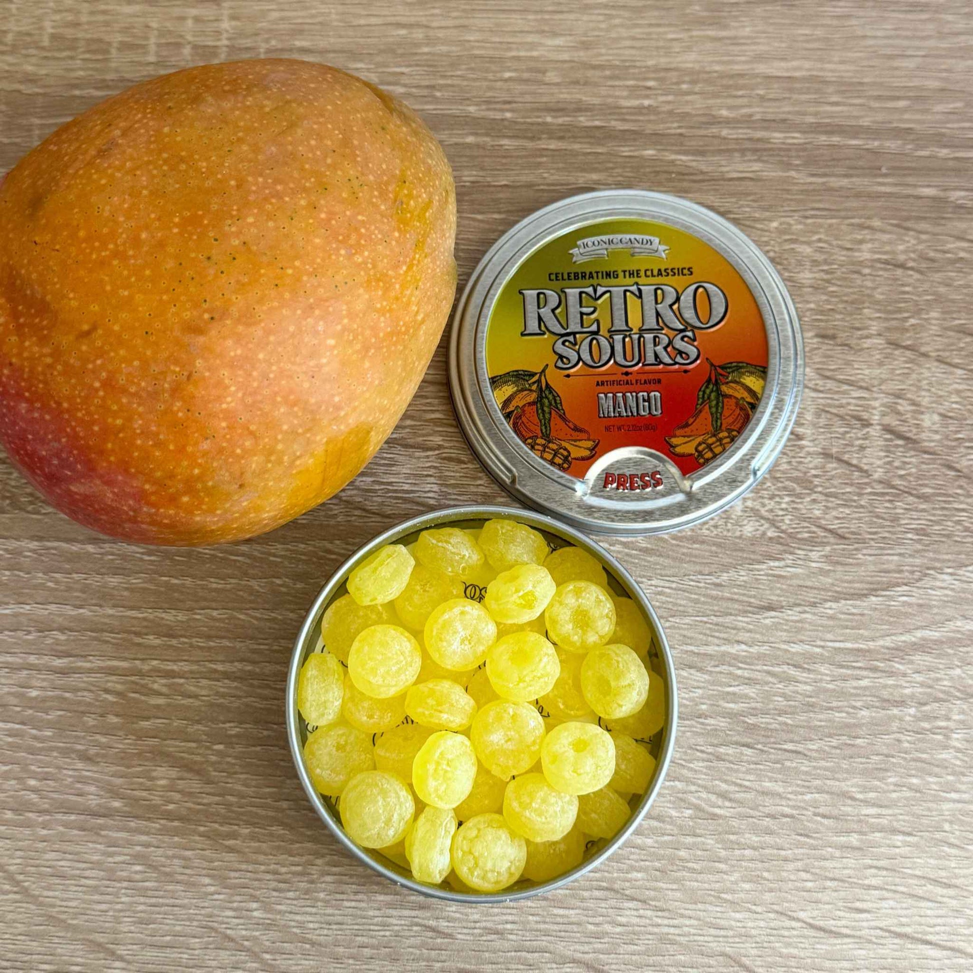 Retro Sours Mango tin with fresh mango slices and colorful packaging