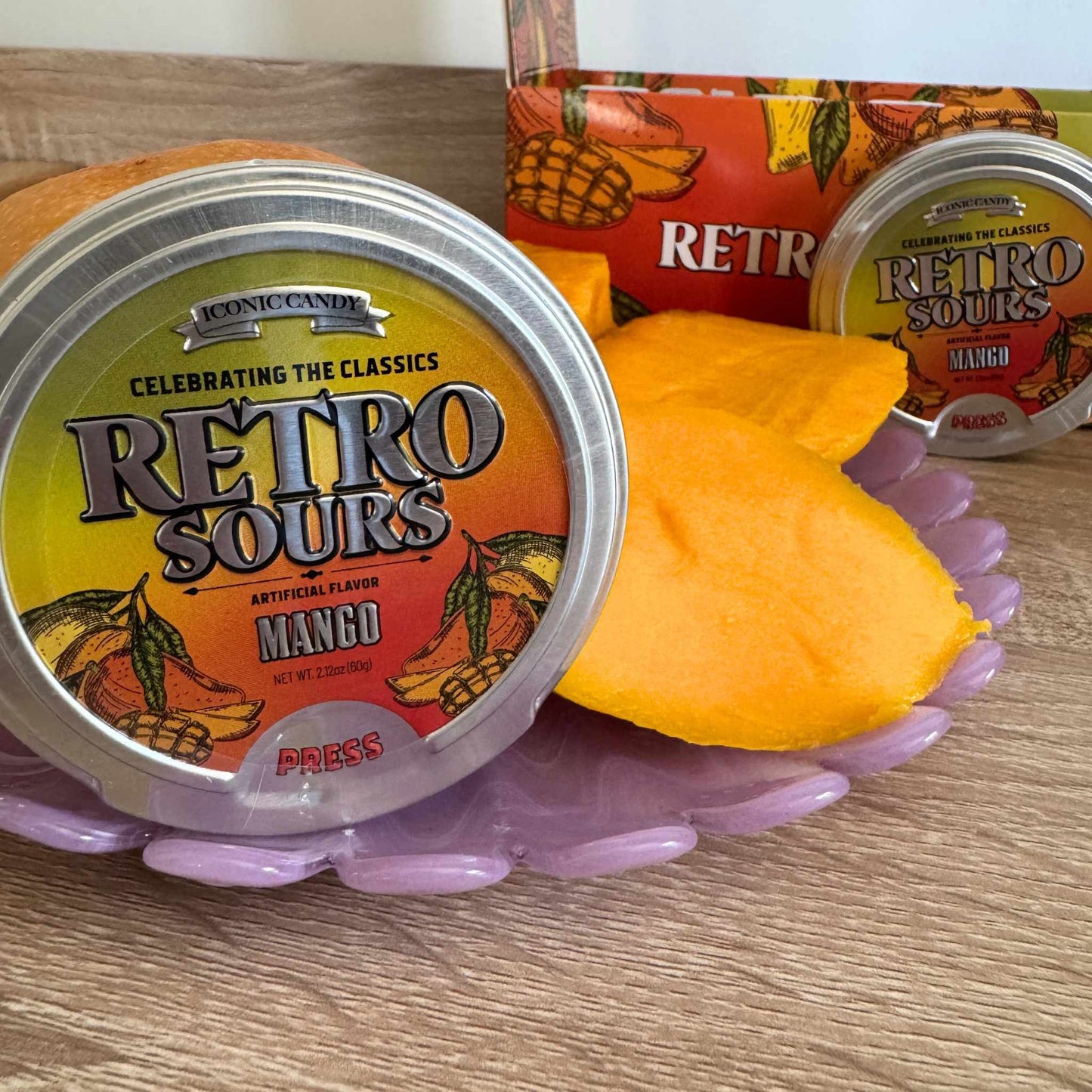 Retro Sours Mango tin with fresh mango slices and colorful packaging